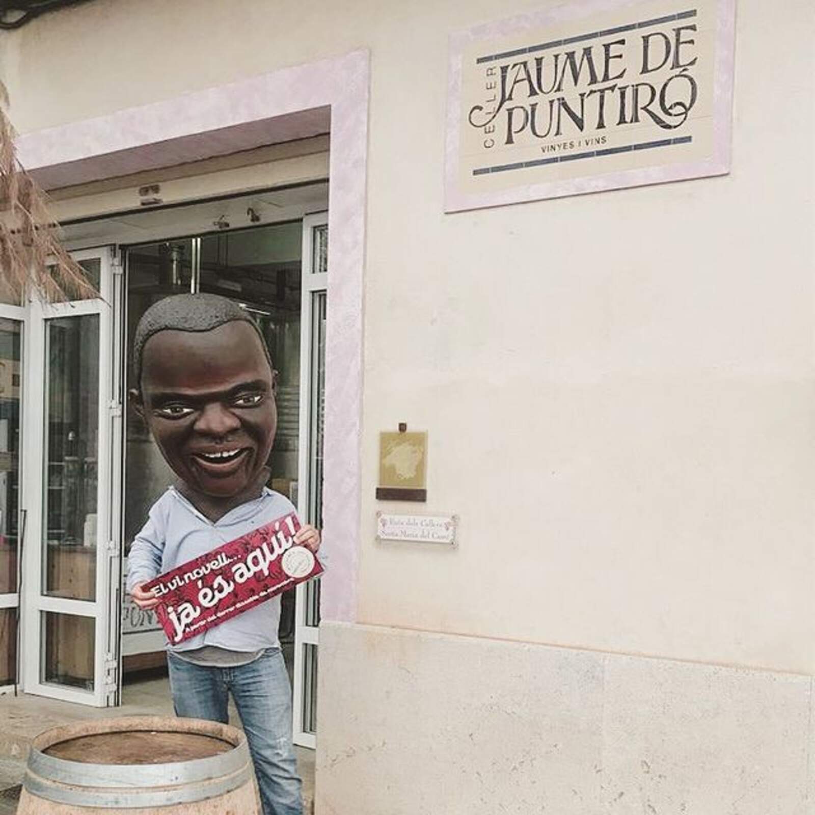 Un dels caparrots que ha esdevingut personatge imprescindible de la festa del Vi Novell, assenyala el celler on s'han de dipositar els cartells que participin en el concurs/Cedida