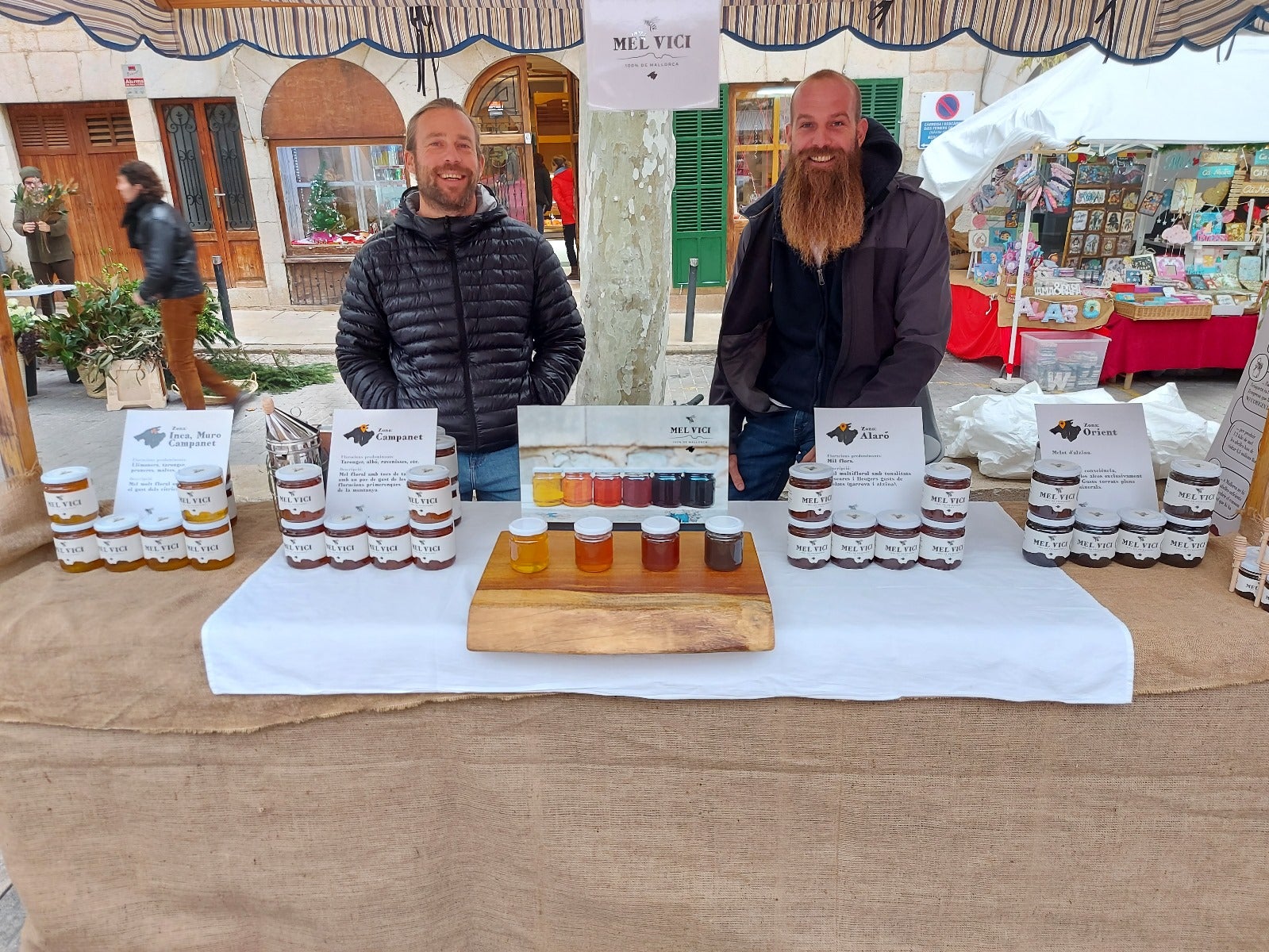 Biel Coll i Pau Ixent Queralt a la parada de mercat on venen la seva mel artesana/Mel Vici